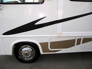 Close-up of a white RV after a paint job with brand new black and brown decals.