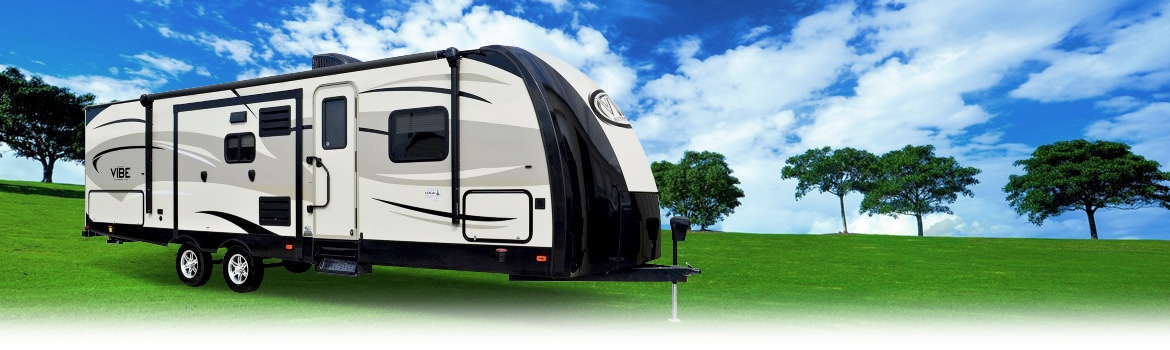 White Forest River Vibe RV parked in a grassy field with trees nearby on a partly cloudy day.